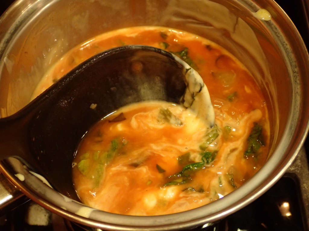 Add ladle of broth to egg mixture